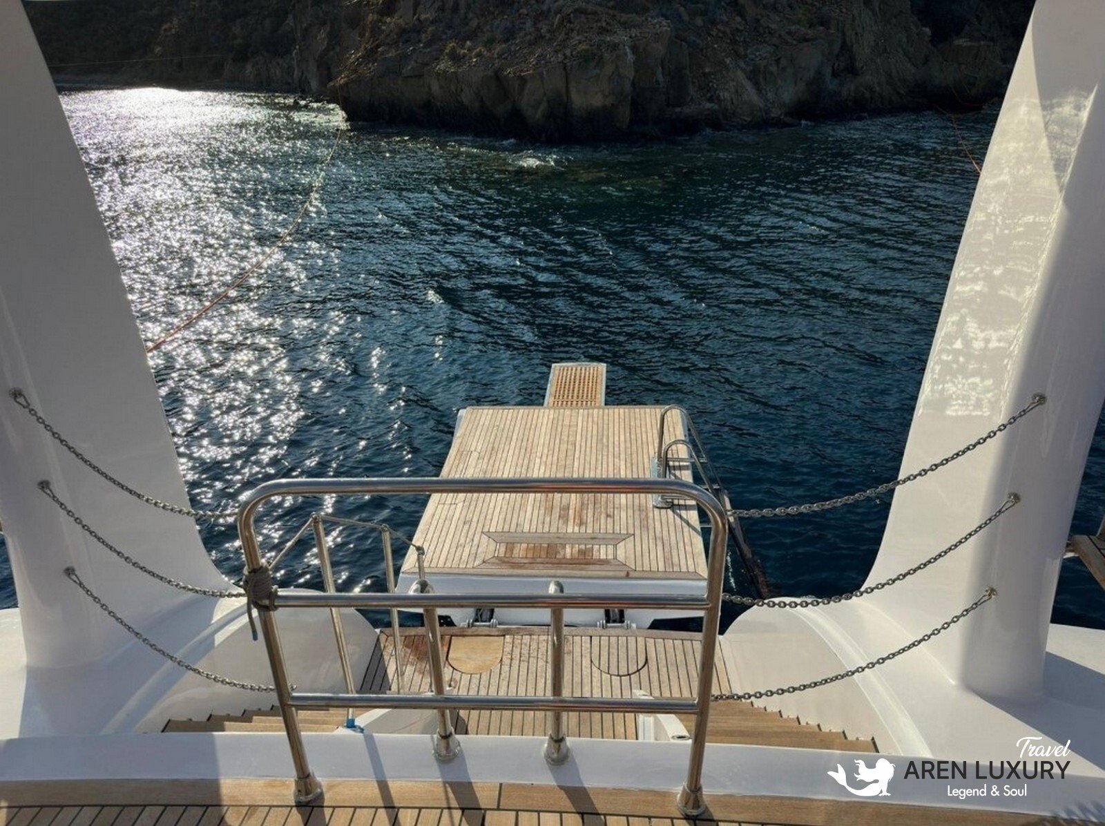High-angle aerial view of the 35m Angelo 3 motorsailer yacht anchored in a deep blue Mediterranean bay.