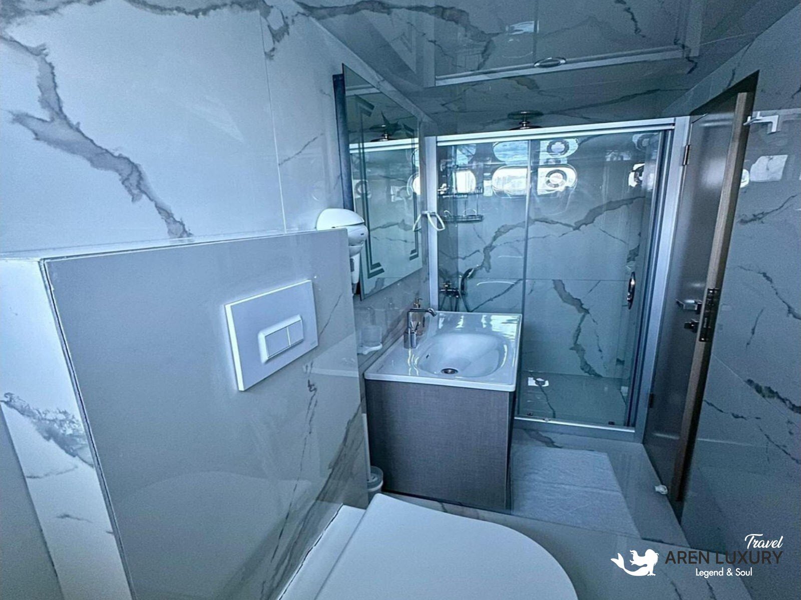 35-meter Angelo 3 motorsailer yacht navigating the crystal clear turquoise waters of a secluded Mediterranean cove.