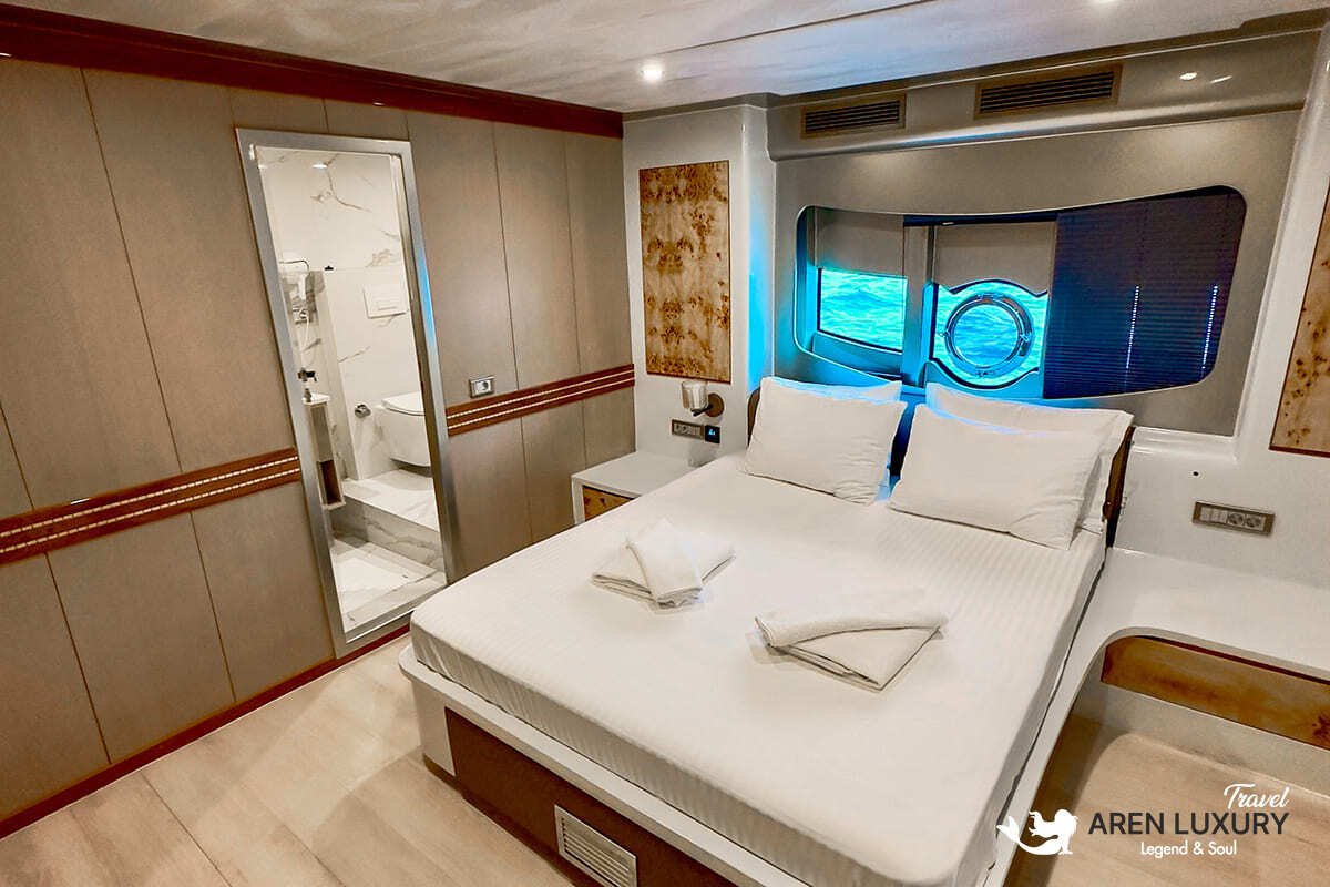 Aerial view of Angelo 3 motorsailer with guests on a hydraulic swim platform and floating dock with paddleboards and kayaks.