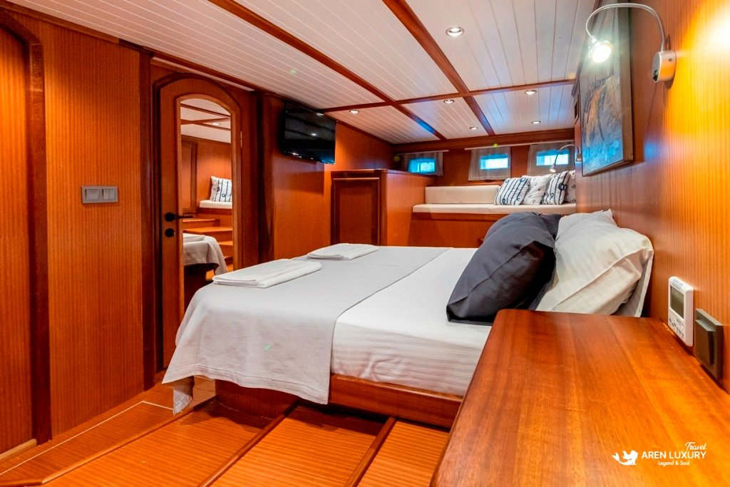 bodrum-queen-gulet-luxury-cabin-interior Luxury master cabin with wood paneling and a large comfortable bed on the Bodrum Queen Gulet.