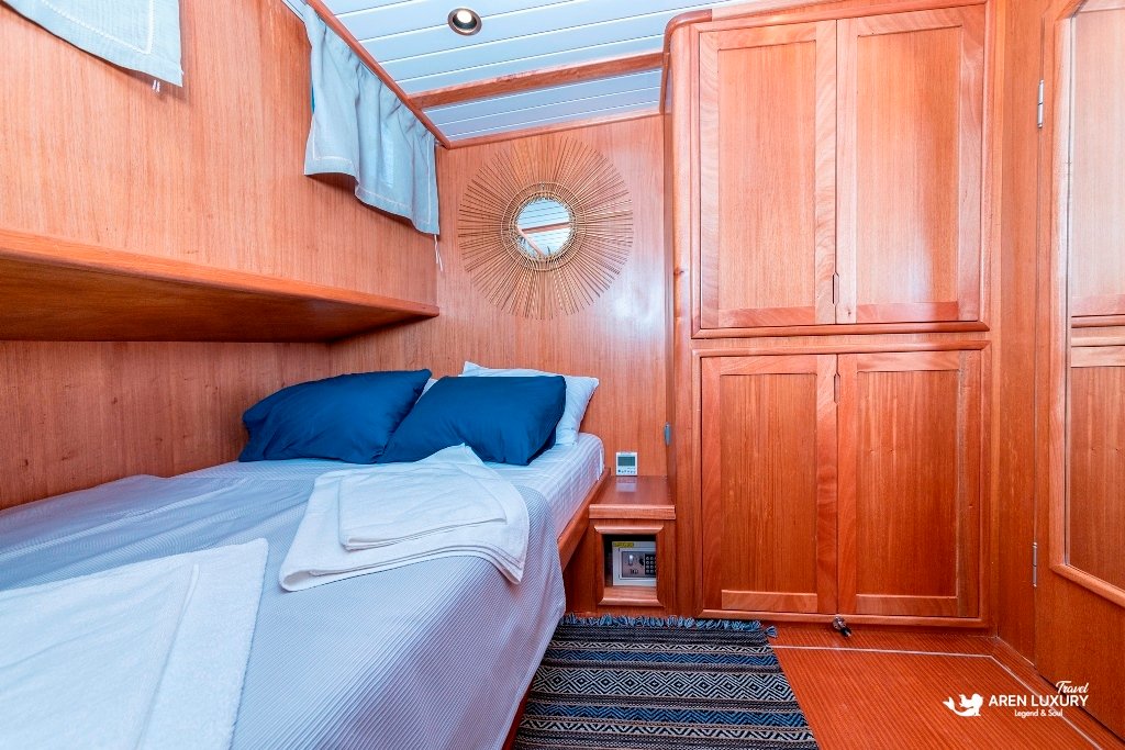 bodrum-queen-gulet-twin-guest-cabin Comfortable twin guest cabin with natural wood finishes and blue accents on the Bodrum Queen Gulet.