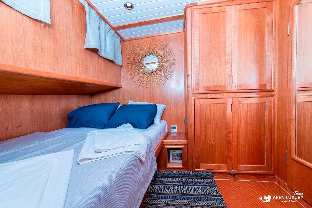 bodrum-queen-gulet-guest-cabin-interior Elegantly designed guest cabin on the Bodrum Queen Gulet with natural wood paneling and blue accents.
