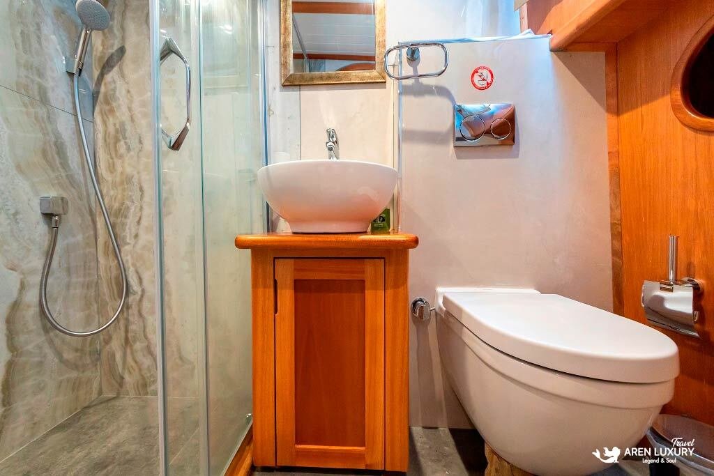 bodrum-queen-gulet-ensuite-shower-interior Modern ensuite bathroom on the Bodrum Queen Gulet with a walk-in glass shower and wooden vanity.