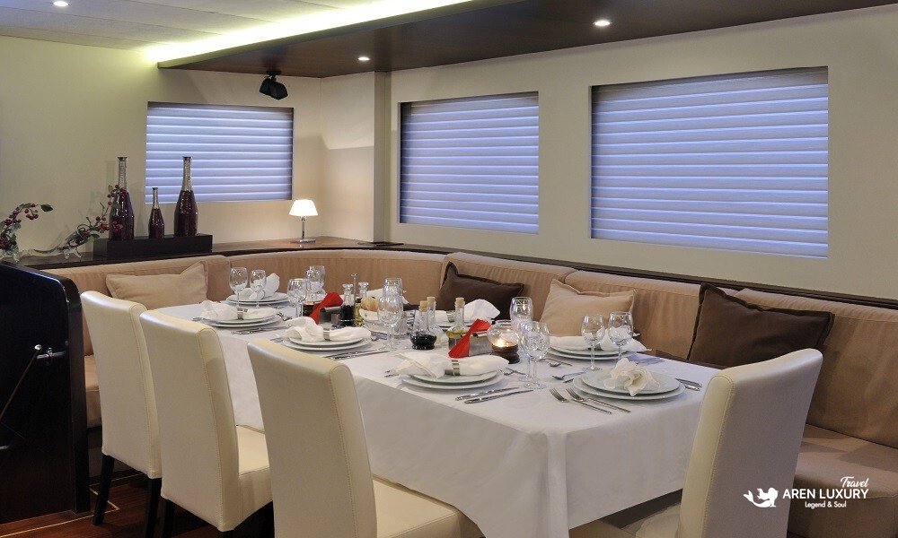 Casa-Dell-Arte-2-Boutique-Yacht-Interior-Art Detail view of the luxury lounge on Casa Dell'Arte 2 gulet, showcasing contemporary art, plush velvet cushions, and warm ambient lighting.