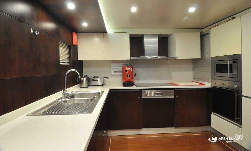 Casa-Dell-Arte-2-Gulet-Gourmet-Galley Fully equipped modern gourmet galley on the Casa Dell'Arte 2 luxury gulet, featuring professional stainless steel appliances and dark wood cabinetry.