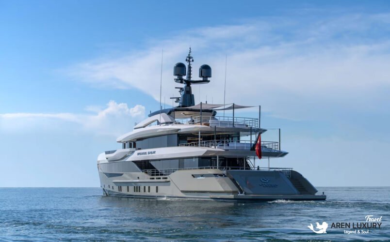 High-angle aerial view of the Eternal Spark superyacht cruising through deep blue water, leaving a white wake.