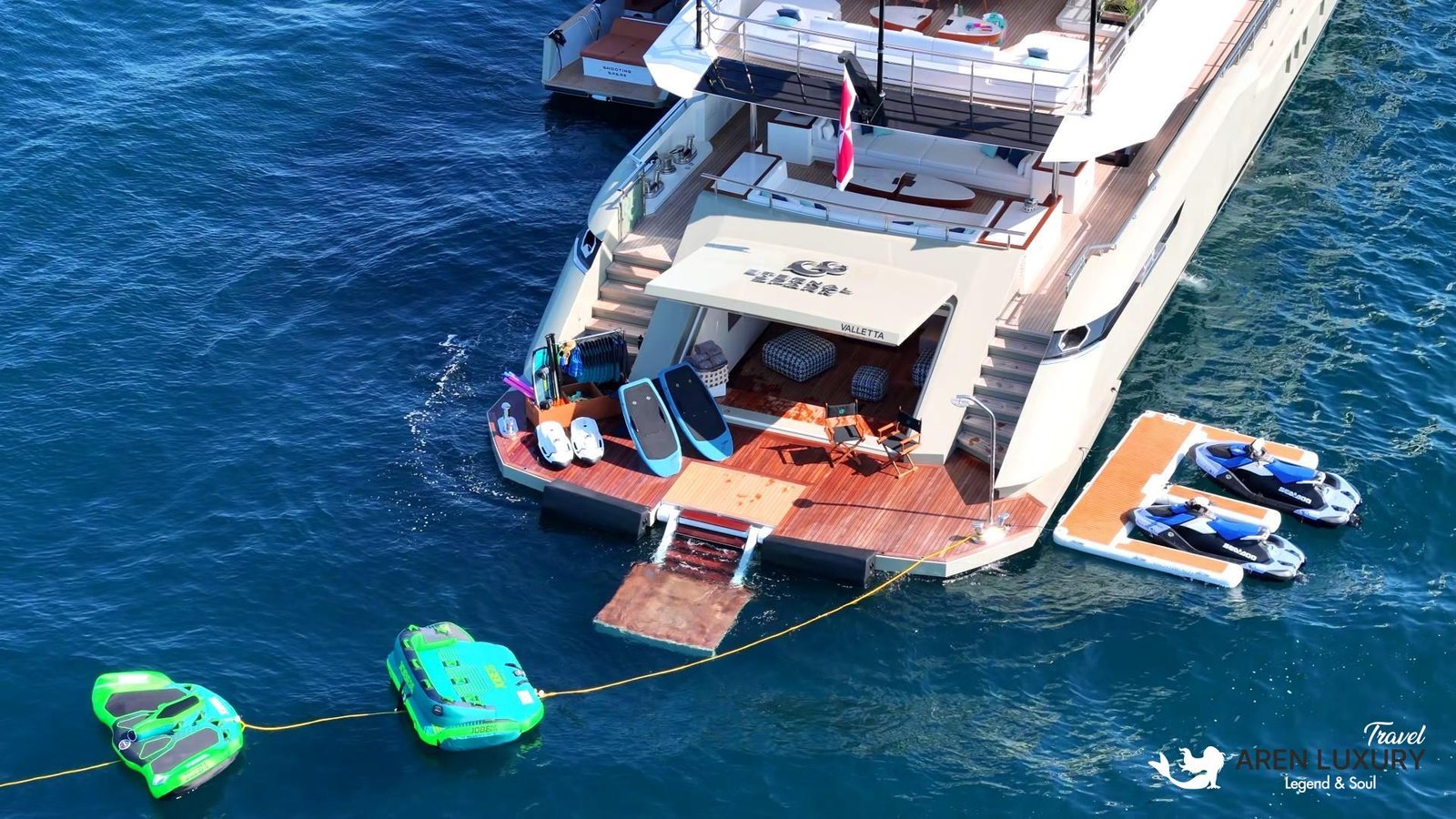 High-angle shot of the Eternal Spark yacht beach club with Jet Skis, paddleboards, and floating platforms ready for use.