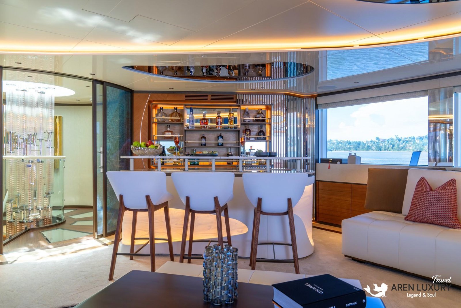 Luxurious main deck bar on Eternal Spark yacht featuring modern white bar stools, a backlit counter, and a comfortable lounge sofa with sea views.