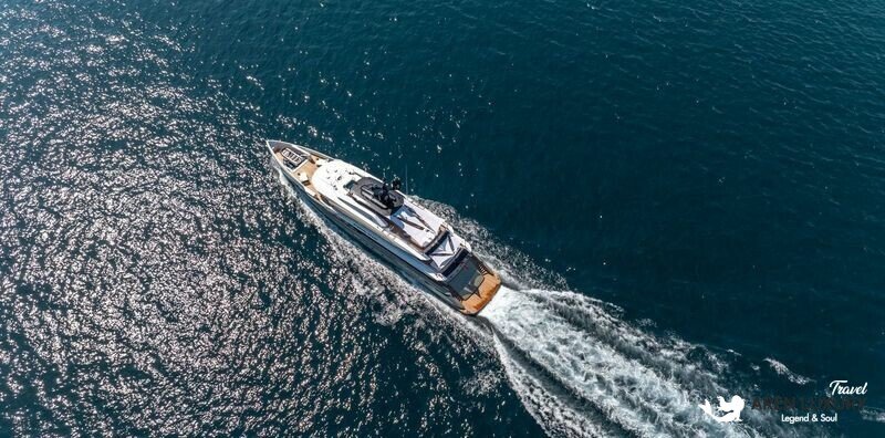 High-angle aerial view of the Eternal Spark superyacht cruising through deep blue water, leaving a white wake.