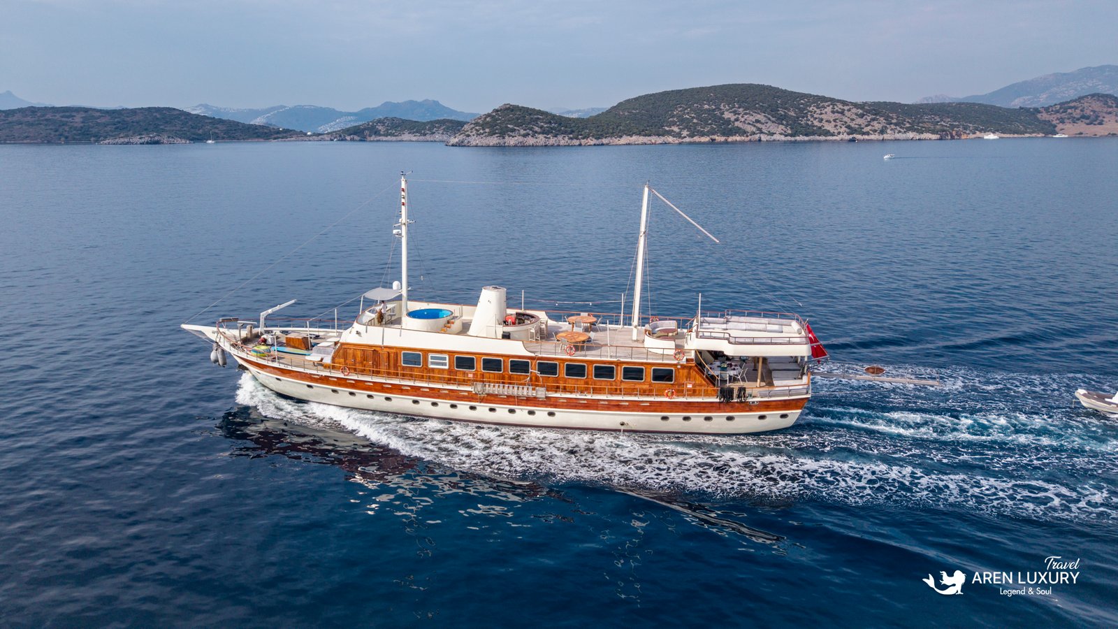 elara-1-luxury-yacht-charter-exterior Full broadside view of the Elara 1 luxury gulet yacht with sun loungers visible on the top deck.