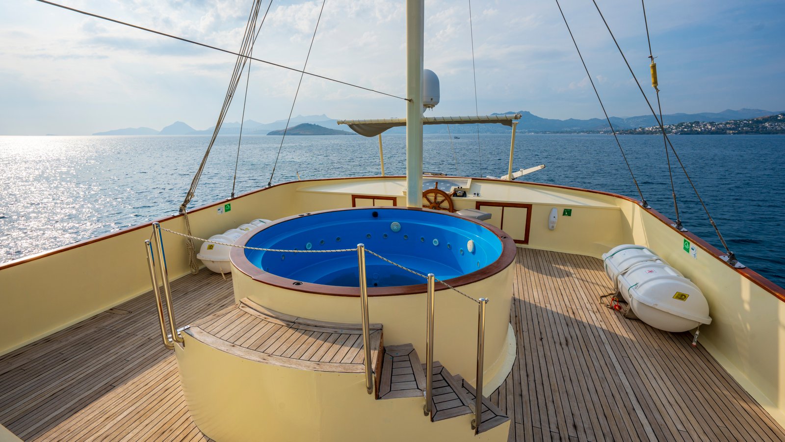 elara-1-gulet-sun-deck-jacuzzi Circular blue jacuzzi on the spacious wooden sun deck of the Elara 1 gulet yacht.