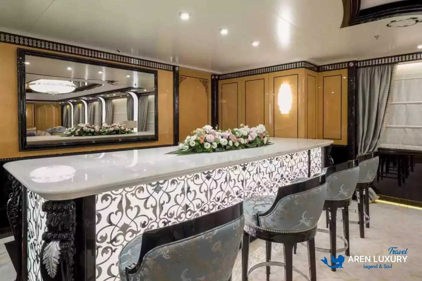 Formal bar and entertainment area on Elements superyacht featuring intricate marble tile patterns.