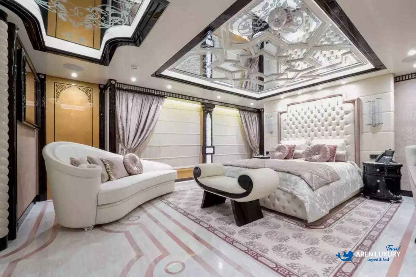 View of the luxurious owner's stateroom on the 80m superyacht Elements, showcasing the etched-mirrored glass detailing and white leather furnishings.
