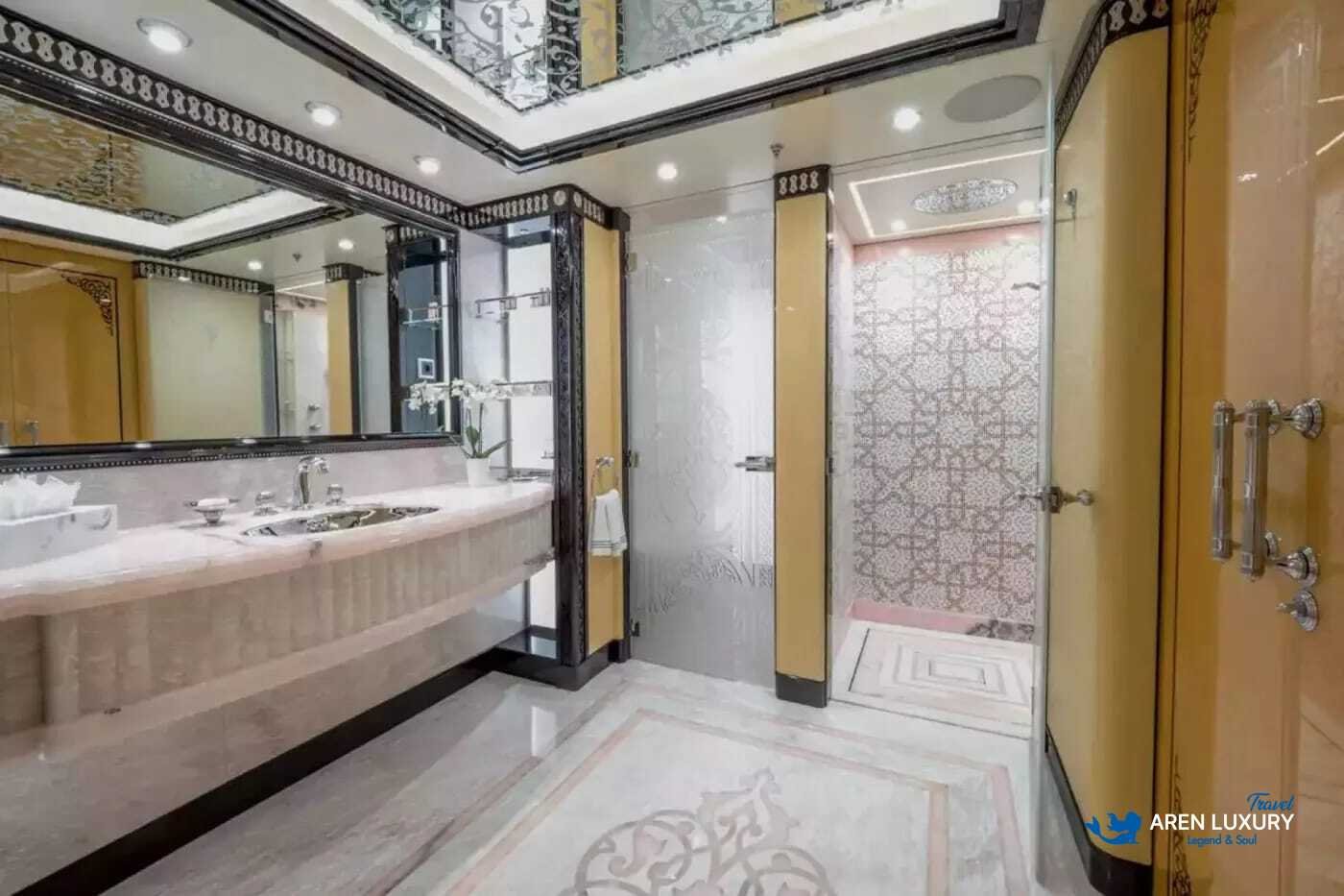 View of the luxurious owner's stateroom on the 80m superyacht Elements, showcasing the etched-mirrored glass detailing and white leather furnishings.