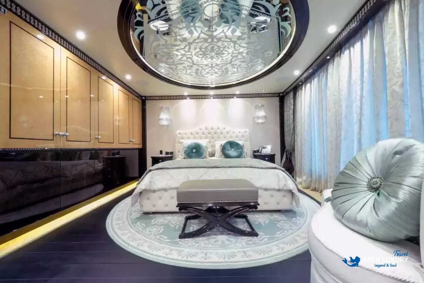 View of the luxurious owner's stateroom on the 80m superyacht Elements, showcasing the etched-mirrored glass detailing and white leather furnishings.