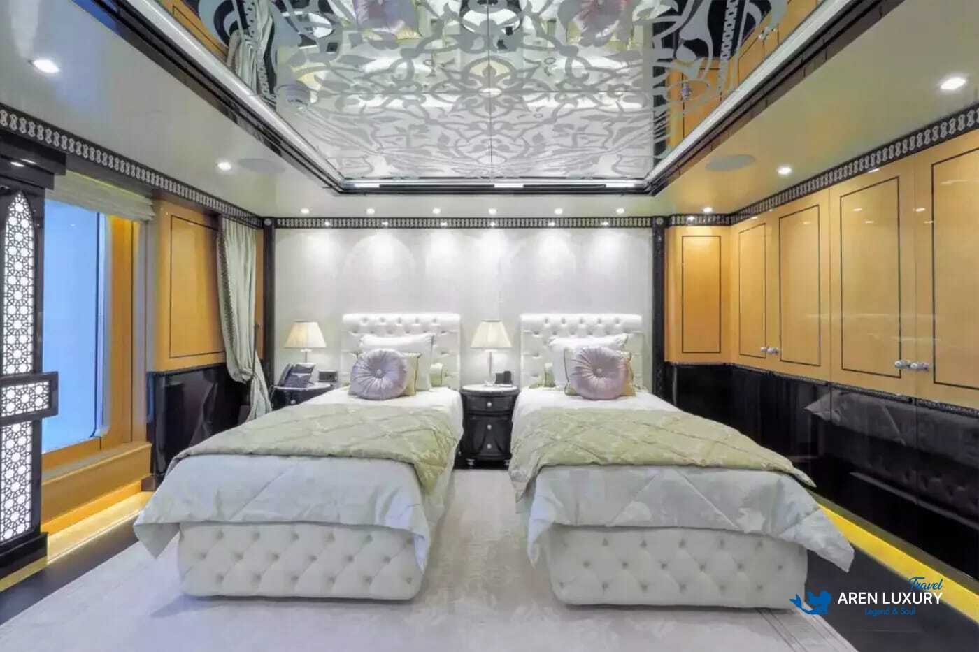 View of the luxurious owner's stateroom on the 80m superyacht Elements, showcasing the etched-mirrored glass detailing and white leather furnishings.