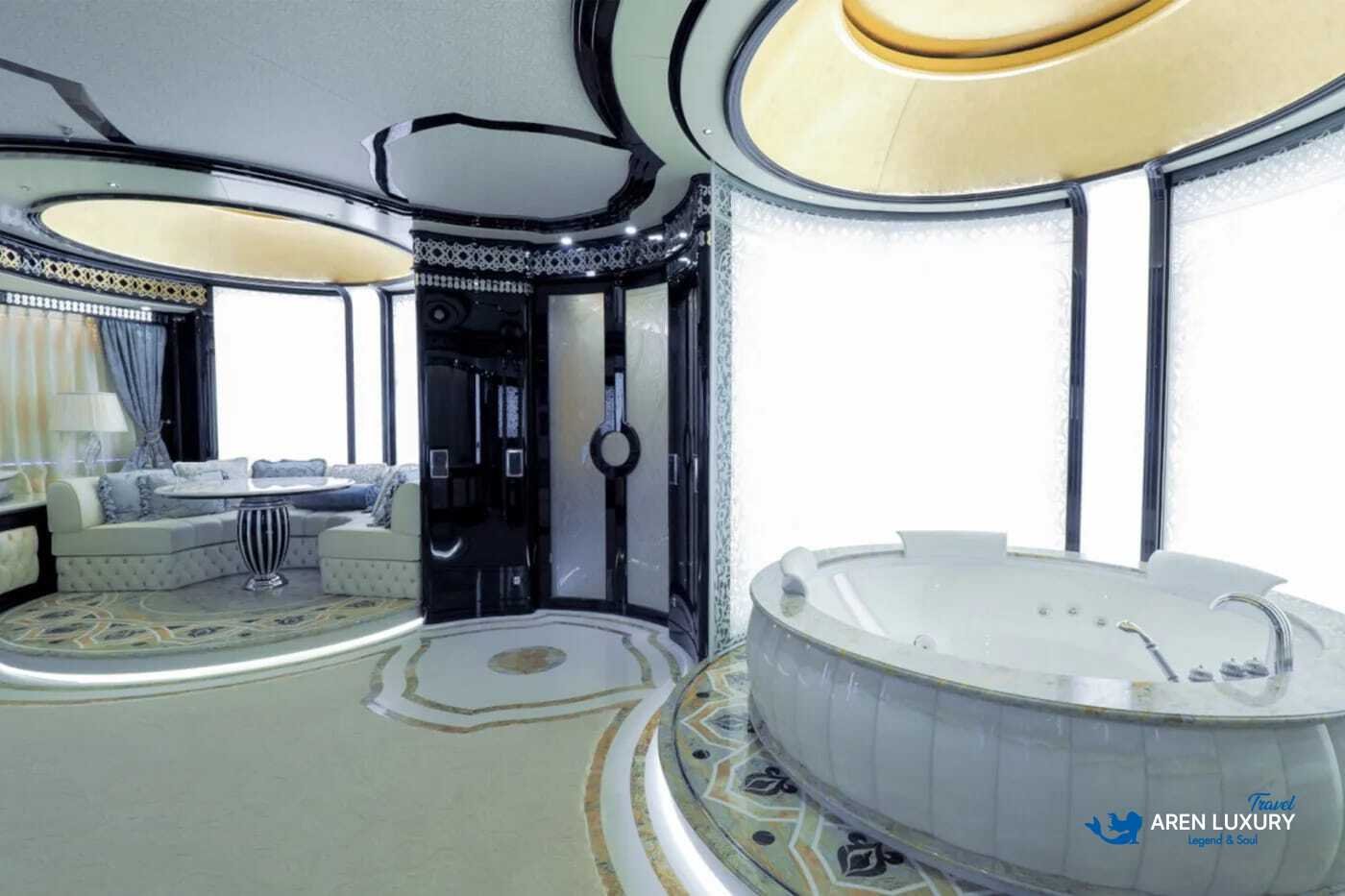 View of the luxurious owner's stateroom on the 80m superyacht Elements, showcasing the etched-mirrored glass detailing and white leather furnishings.