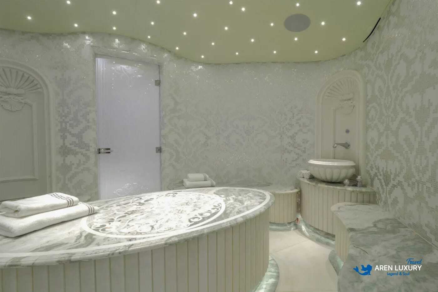 View of the luxurious owner's stateroom on the 80m superyacht Elements, showcasing the etched-mirrored glass detailing and white leather furnishings.