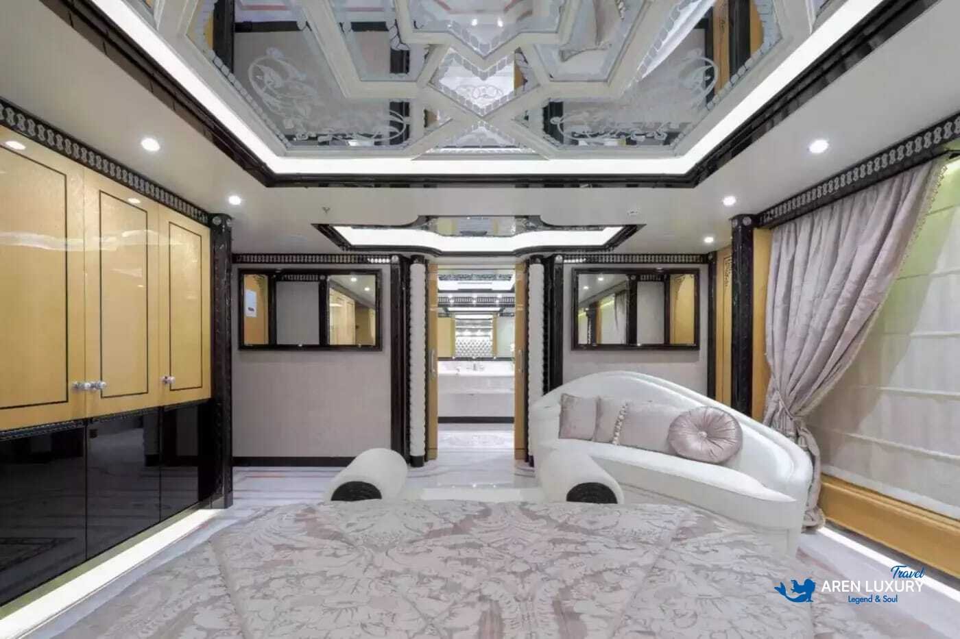 View of the luxurious owner's stateroom on the 80m superyacht Elements, showcasing the etched-mirrored glass detailing and white leather furnishings.