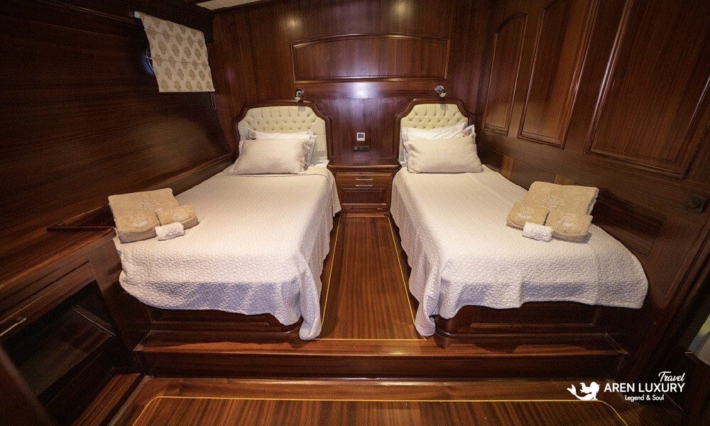 Twin guest cabin on Arif Kaptan A gulet featuring rich mahogany wood paneling.