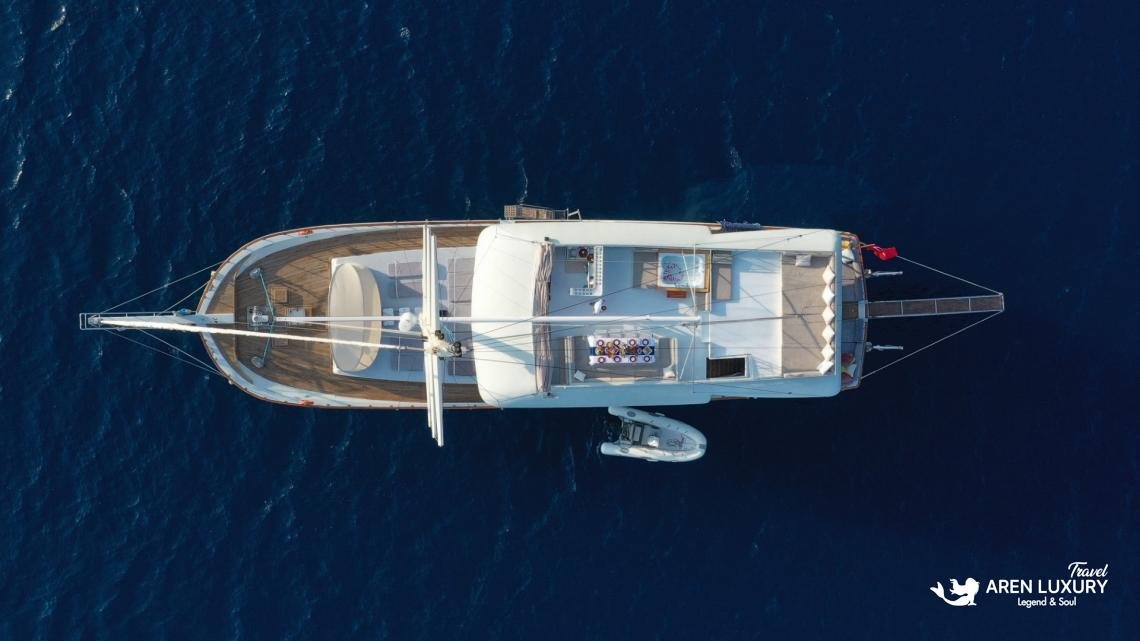 gulet-freedom-aerial-drone-view-luxury-charter Aerial drone view of luxury ketch Gulet Freedom at sea, featuring flybridge and deck lounge.