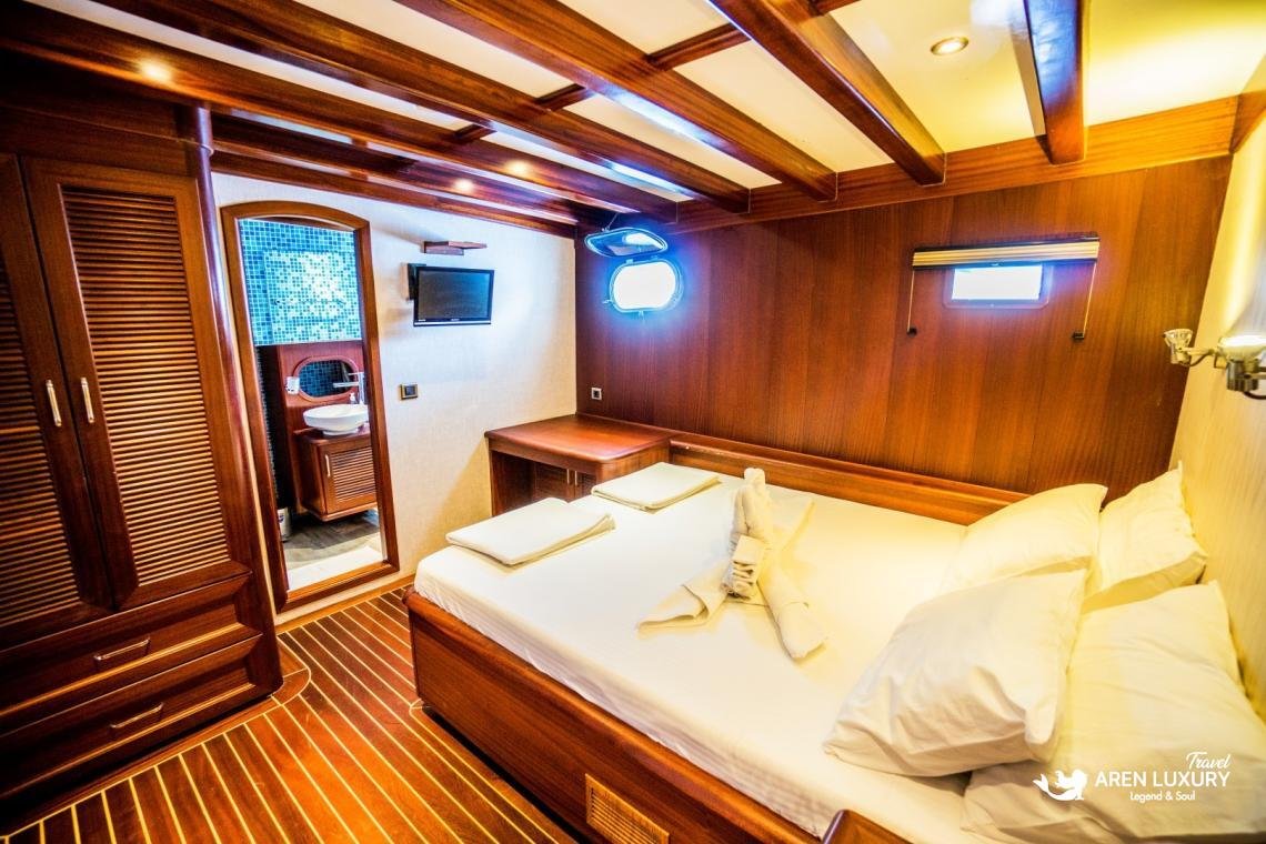 gulet-freedom-luxury-triple-guest-cabin-interior Modern triple cabin on Gulet Freedom featuring a large double bed, an additional single bed, and built-in wooden wardrobes.
