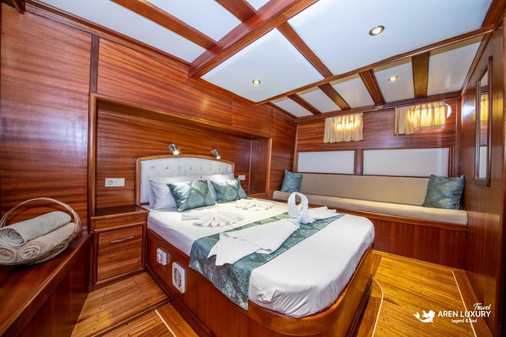 Spacious master cabin on the Gulet Gokce, highlighting luxury yacht accommodation with traditional mahogany finishes.