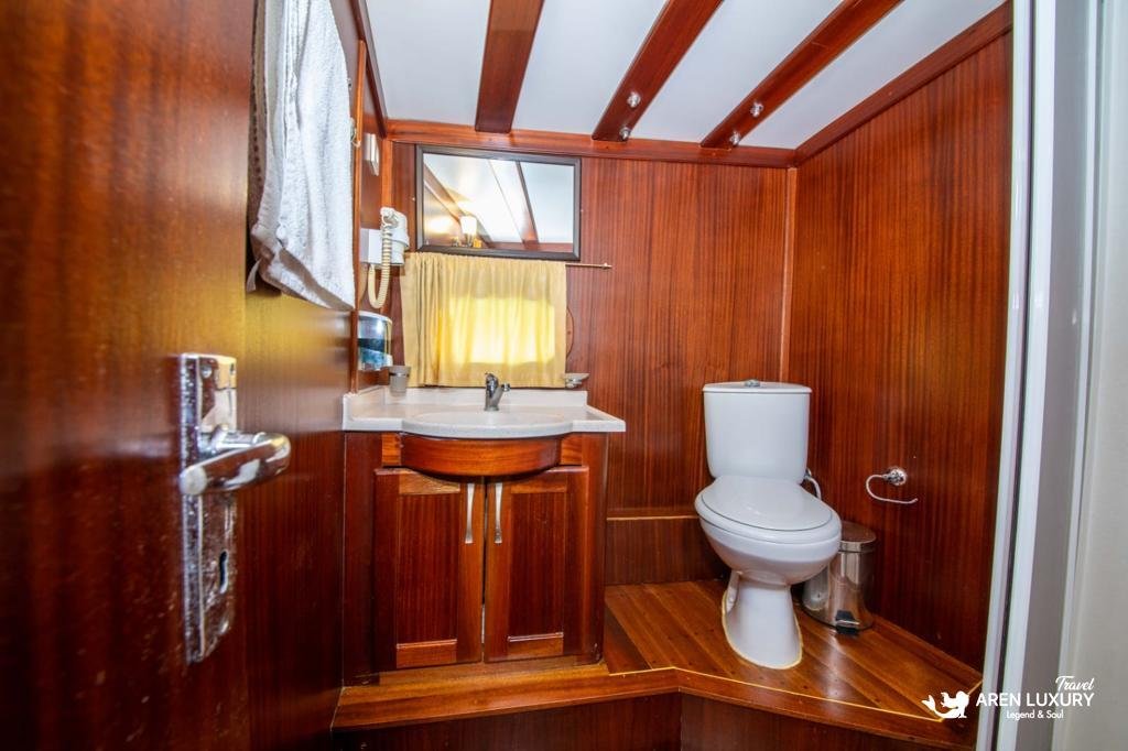 Modern en-suite bathroom on Gulet Gokce with a walk-in shower, marble-effect tiling, and a mahogany vanity.