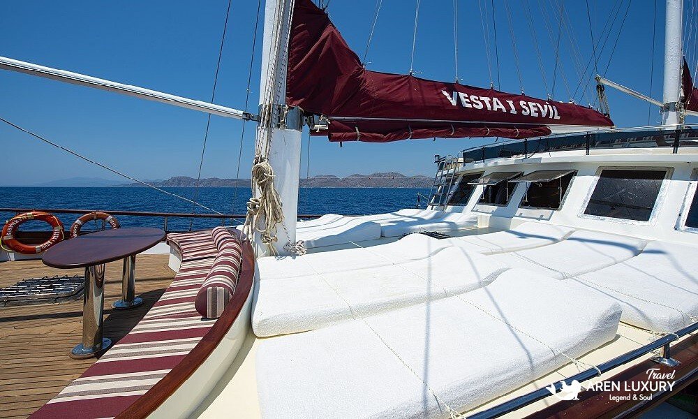 Gulet Vesta 1 Sevil luxury sunbathing deck with comfortable white cushions and red sail covers