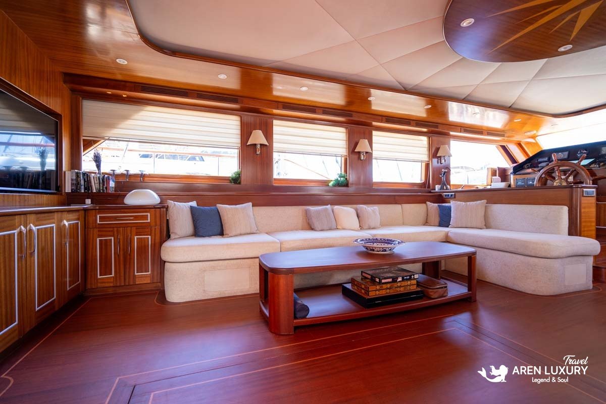 Luxury interior of Gulet La Bella Vita main salon featuring plush cream sofas, a coffee table, and large panoramic windows.