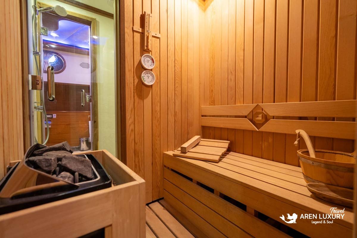 Interior view of a traditional wooden sauna on a luxury gulet yacht with authentic cedar benches and volcanic rocks.
