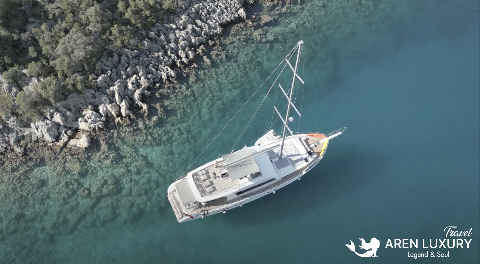 Gulet Albatros M Aerial View and Turquoise Waters Aerial top view of Gulet Albatros M anchored in crystal clear turquoise waters near a rocky coastline.