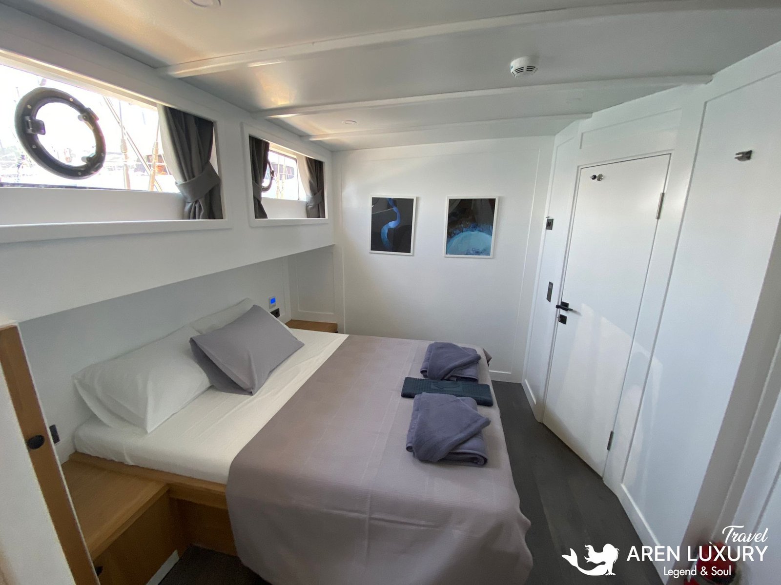 Gulet Albatros M Forward Port Cabin Modern en-suite double cabin on the forward port side of Gulet Albatros M featuring porthole windows and minimalist decor.