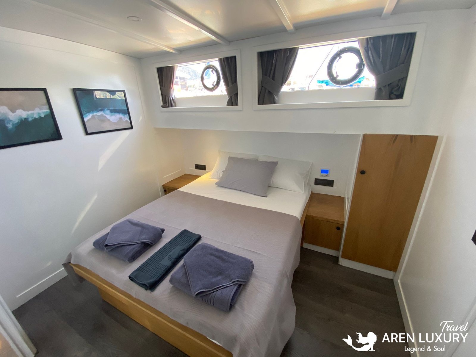 Gulet Albatros M Forward Starboard Cabin Contemporary double guest cabin on the forward starboard side of Gulet Albatros M with minimalist wooden furniture and porthole views.