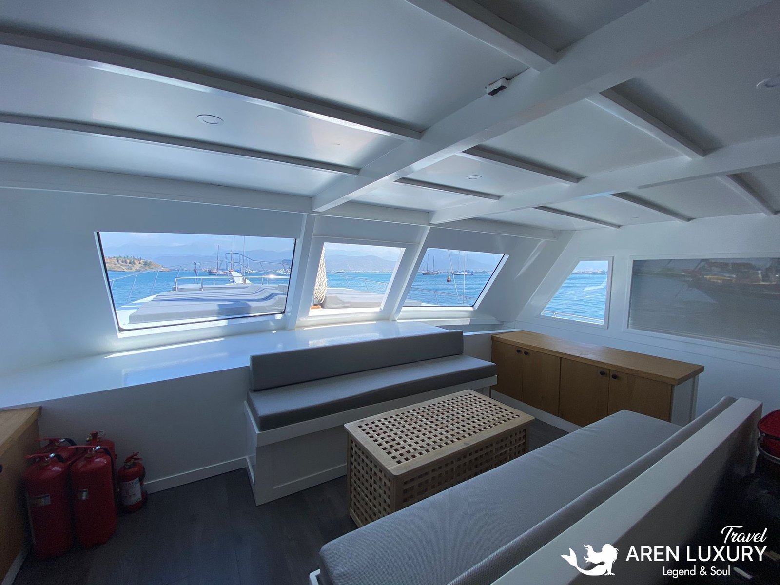 Gulet Charter Albatros M Modern Indoor Salon Spacious indoor lounge of Gulet Albatros M with panoramic windows, modern gray sofas, and natural wood cabinetry.